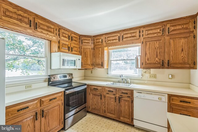 21821 Cove Ln, Leonardtown, MD 20650 - kitchen featuring white appliances, a sink, light floors, light countertops, and brown cabinets