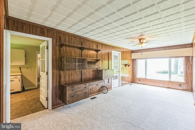 21821 Cove Ln, Leonardtown, MD 20650 - unfurnished living room with wood walls, ceiling fan, carpet floors, crown molding, and baseboards