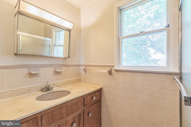 21821 Cove Ln, Leonardtown, MD 20650 - bathroom featuring tile walls, healthy amount of natural light, vanity, crown molding, and a wainscoted wall