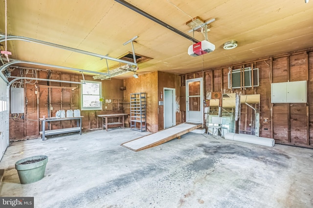 21821 Cove Ln, Leonardtown, MD 20650 - garage featuring a garage door opener, electric panel, and wood walls