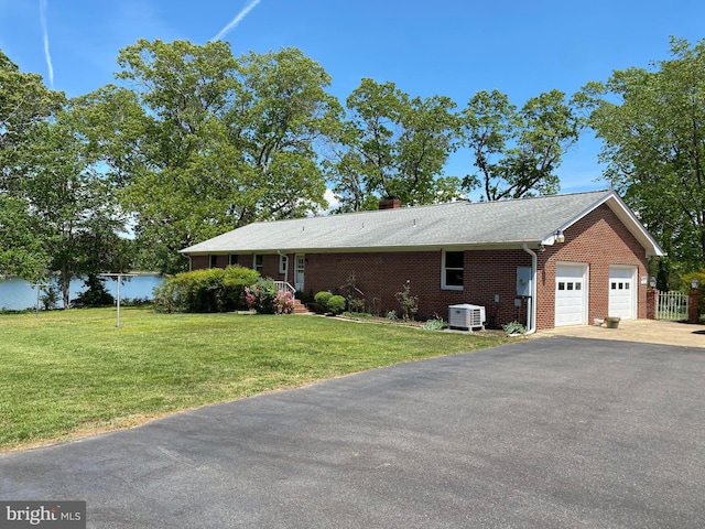 21821 Cove Ln, Leonardtown, MD 20650 - view of home's exterior featuring central AC, a garage, brick siding, driveway, and a lawn