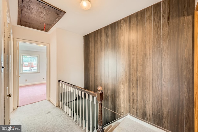 stairs with attic access, carpet floors, and baseboards