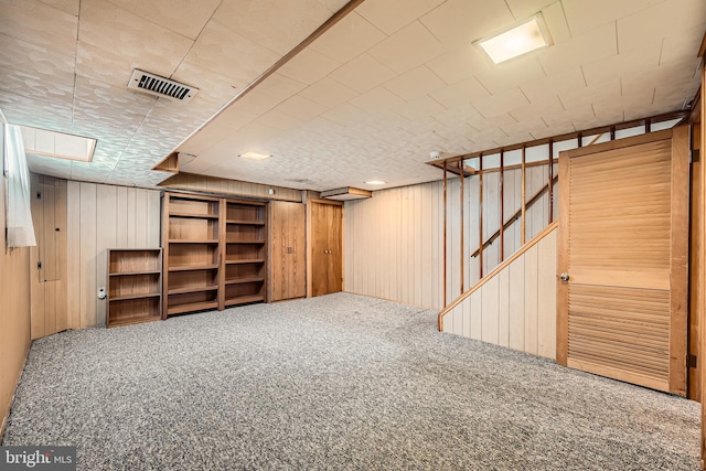 finished below grade area featuring carpet floors and wooden walls