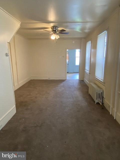 511 W Arch St, Pottsville, PA 17901 - unfurnished living room with radiator, a ceiling fan, carpet floors, and baseboards