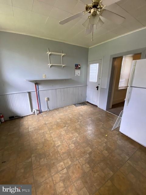 511 W Arch St, Pottsville, PA 17901 - kitchen with freestanding refrigerator, a ceiling fan, and wainscoting