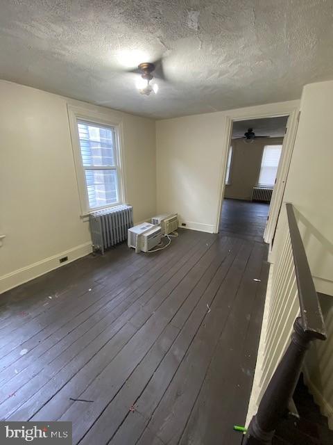 511 W Arch St, Pottsville, PA 17901 - spare room with radiator, a textured ceiling, healthy amount of natural light, dark wood-style floors, and baseboards