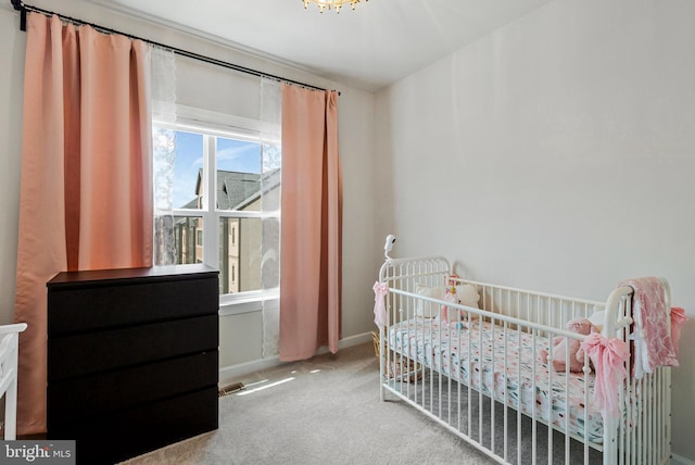 bedroom featuring carpet floors, a nursery area, and baseboards