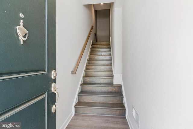 stairs featuring wood finished floors and baseboards