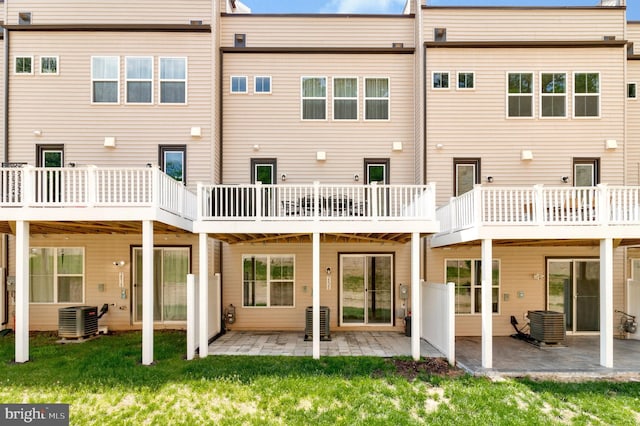 back of property with central air condition unit, a patio, and a yard