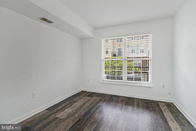unfurnished room with dark wood-type flooring and baseboards