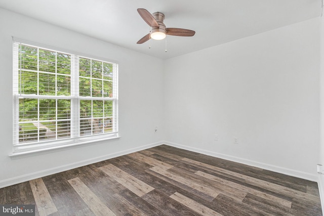 empty room with ceiling fan, baseboards, and dark wood finished floors