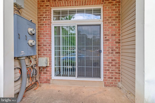 doorway to property featuring brick siding