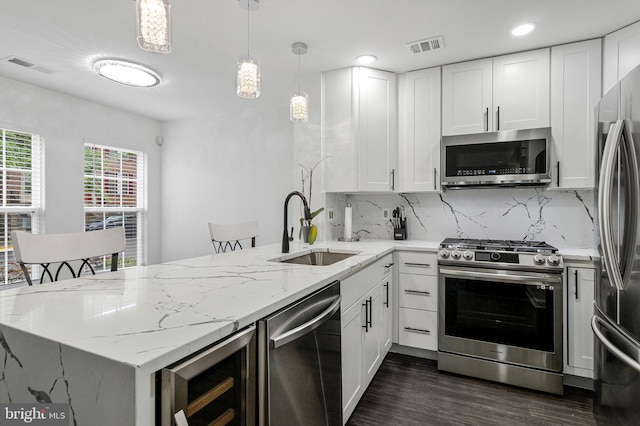 kitchen featuring stainless steel appliances, beverage cooler, a sink, a peninsula, and dark wood-style flooring