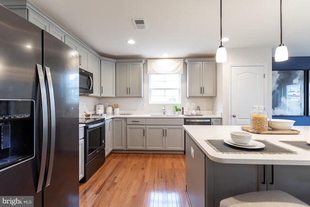 HOMESITE96 Pheasant Ridge Rd, Hanover, PA 17331 - kitchen with appliances with stainless steel finishes, gray cabinetry, a sink, light wood-type flooring, and light countertops