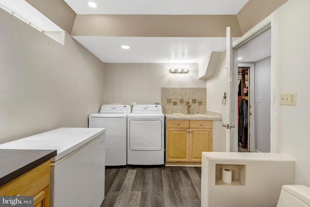 clothes washing area with washer and dryer, dark wood-type flooring, and recessed lighting