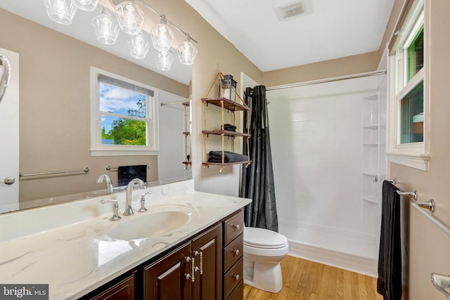 full bathroom featuring a shower with curtain, toilet, vanity, and wood finished floors