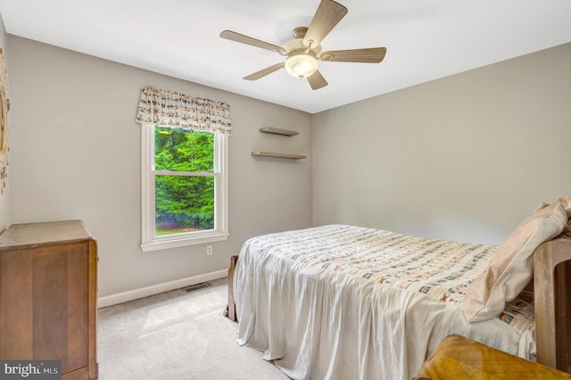 bedroom featuring baseboards, light colored carpet, and a ceiling fan