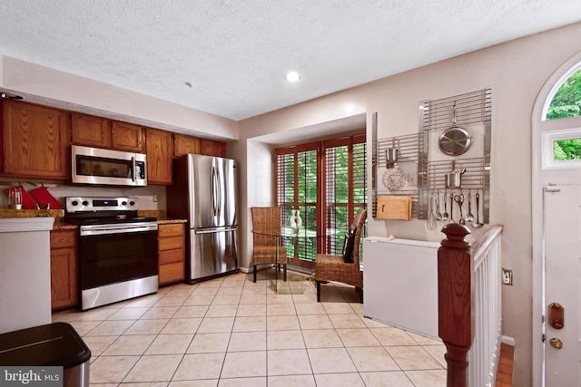 630 Brookedge Ct, Bowie, MD 20721 - kitchen with appliances with stainless steel finishes, brown cabinets, light tile patterned floors, a textured ceiling, and recessed lighting