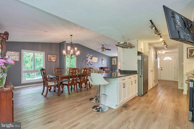 kitchen with freestanding refrigerator, light wood-type flooring, white cabinets, baseboards, and vaulted ceiling