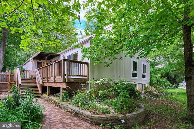 back of property featuring a wooden deck and stairway