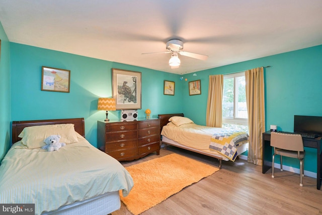 bedroom with wood finished floors, ceiling fan, and baseboards