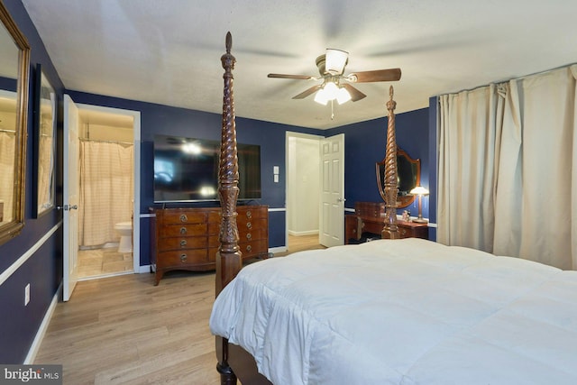 bedroom with baseboards, wood finished floors, and ensuite bathroom