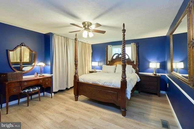 bedroom featuring wood finished floors, a ceiling fan, and baseboards