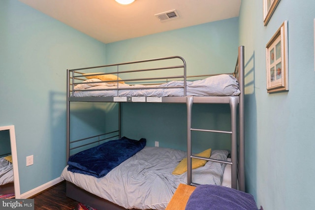 bedroom with wood finished floors and baseboards