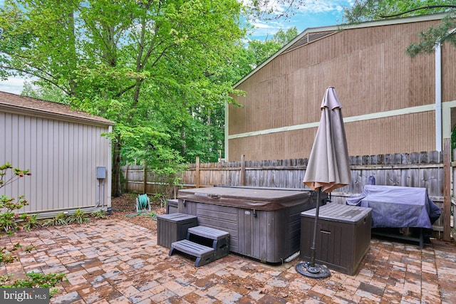 view of patio / terrace with a hot tub and a fenced backyard