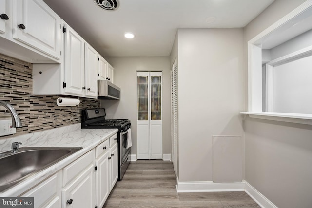 12705 Gordon Blvd Unit 37, Woodbridge, VA 22192 - kitchen featuring appliances with stainless steel finishes, tasteful backsplash, white cabinetry, light wood-style flooring, and recessed lighting