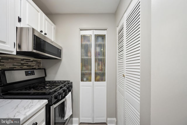 12705 Gordon Blvd Unit 37, Woodbridge, VA 22192 - kitchen with stainless steel appliances, decorative backsplash, white cabinets, and light stone counters