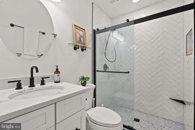 bathroom with a shower stall, toilet, and vanity