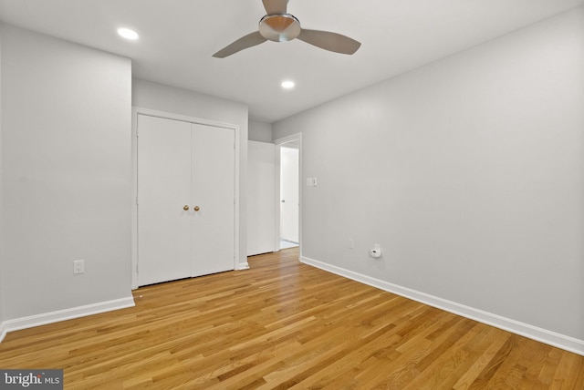 unfurnished bedroom featuring light wood-style flooring, baseboards, a closet, and recessed lighting