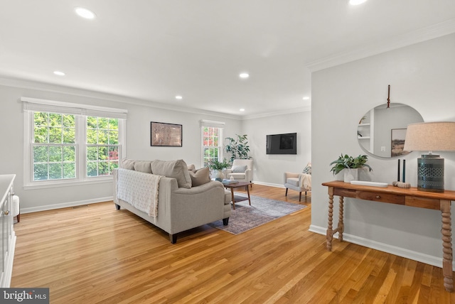 living room with ornamental molding, light wood-style flooring, recessed lighting, and baseboards