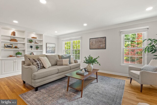 living room featuring crown molding, light wood-style flooring, recessed lighting, and baseboards