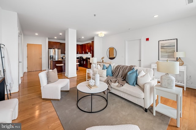 living area with light wood-type flooring and recessed lighting