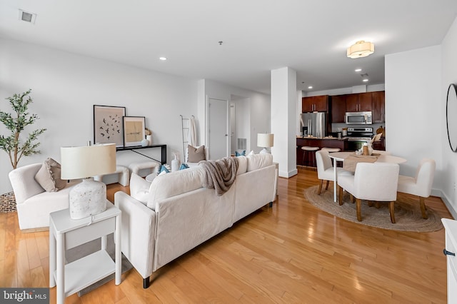 living area featuring light wood-style floors, recessed lighting, and baseboards