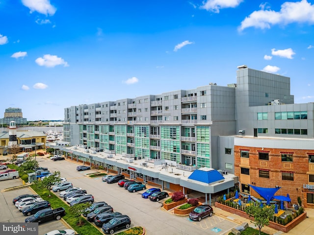 view of property with uncovered parking and a view of city