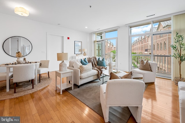 living area featuring healthy amount of natural light, light wood-style flooring, and recessed lighting