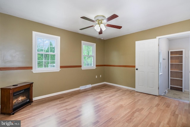 unfurnished bedroom with light wood-type flooring, baseboards, and ceiling fan