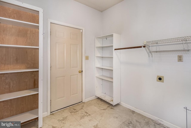 laundry area with hookup for an electric dryer, marble finish floors, and baseboards