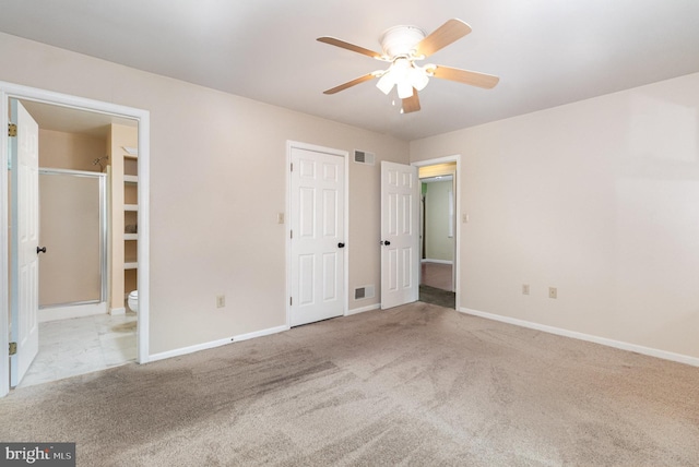 unfurnished bedroom with carpet flooring, baseboards, and ensuite bathroom