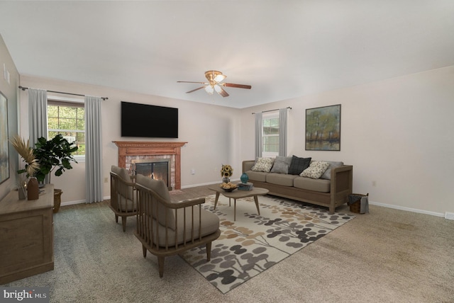 living area with ceiling fan, carpet, a brick fireplace, and baseboards