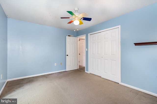 unfurnished bedroom featuring carpet, baseboards, a closet, and a ceiling fan