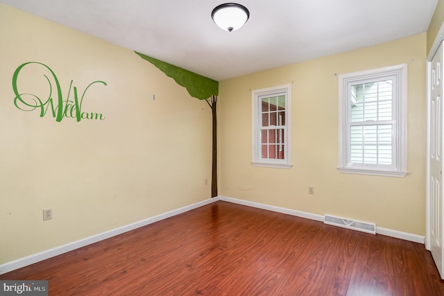 spare room featuring wood finished floors and baseboards