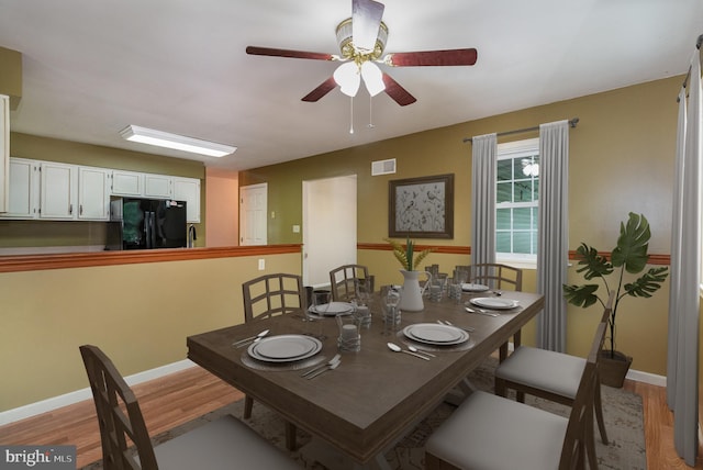 dining space featuring light wood-style floors, baseboards, and a ceiling fan