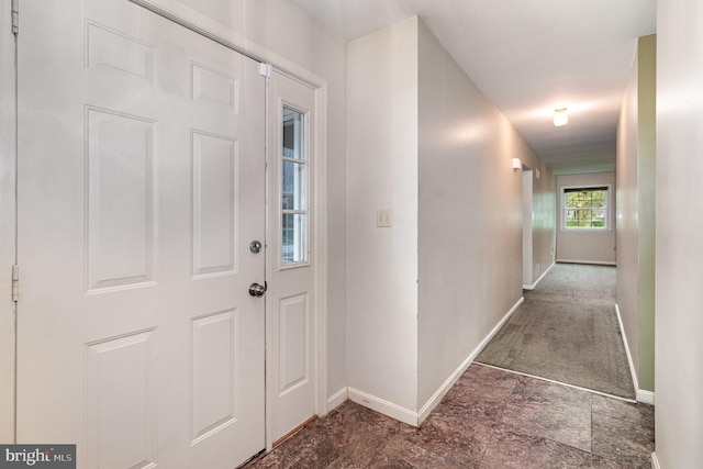 hallway with baseboards and stone finish flooring