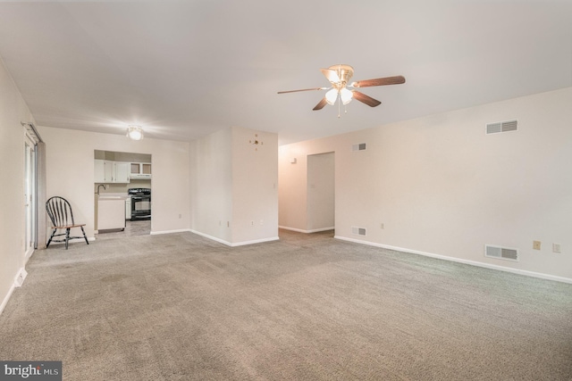 unfurnished living room with a ceiling fan, light carpet, and baseboards