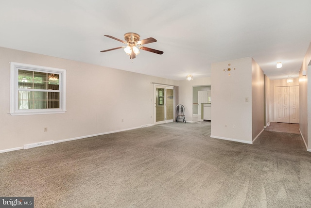 unfurnished living room with a ceiling fan, carpet floors, and baseboards