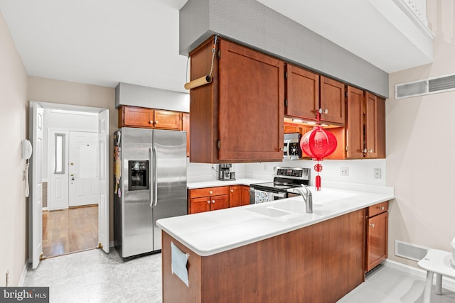 72 Leearden Rd, Hershey, PA 17033 - kitchen with appliances with stainless steel finishes, a peninsula, light countertops, baseboards, and brown cabinetry